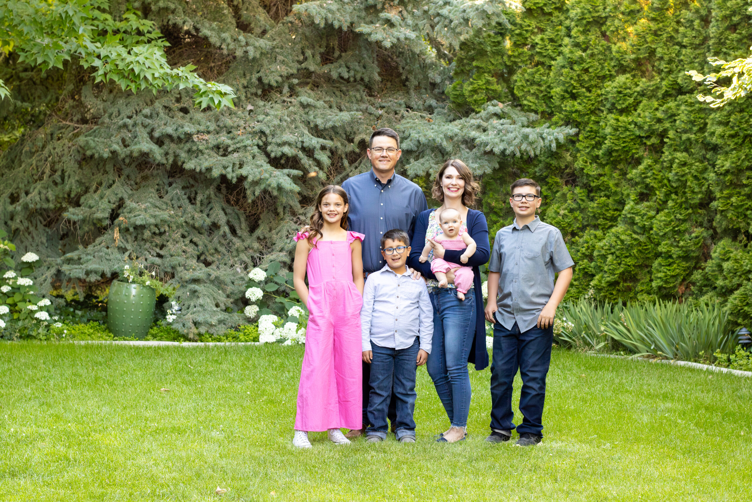 The Corry family in front of a cedar tree, parents and children