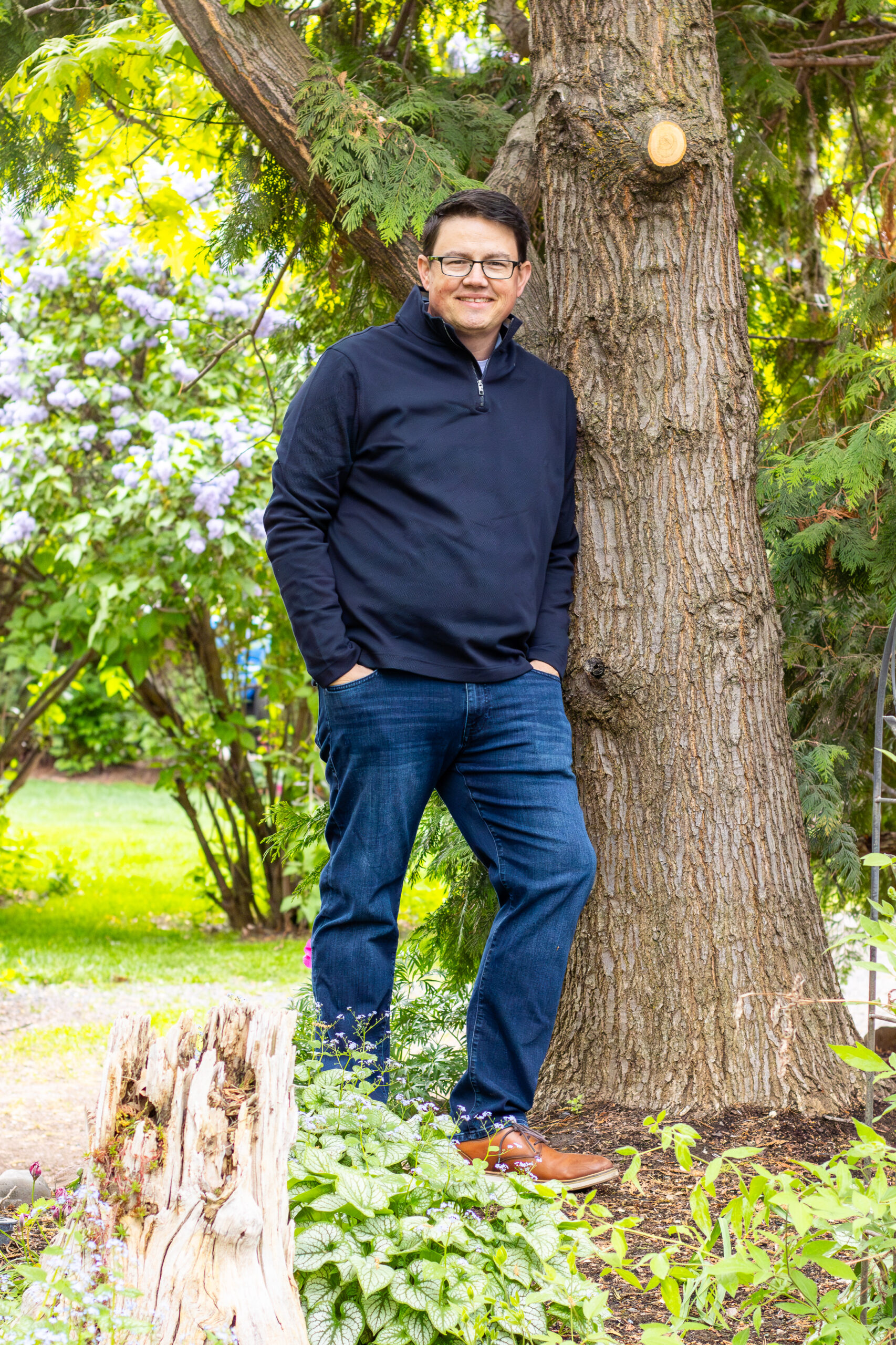 Chris Corry leaning against a tree for a portrait