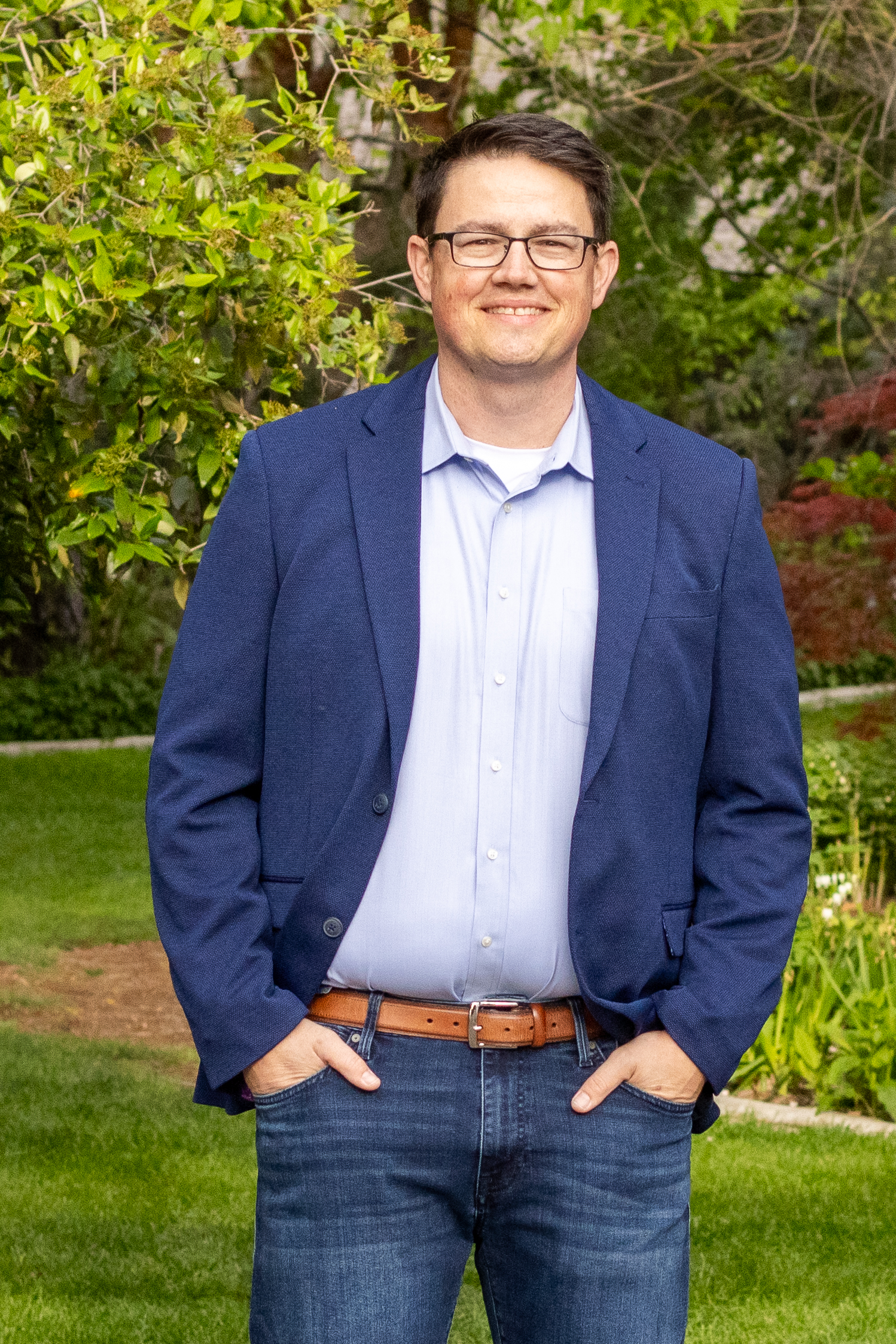 Chris Corry, in a navy blazer, in an outdoor park setting