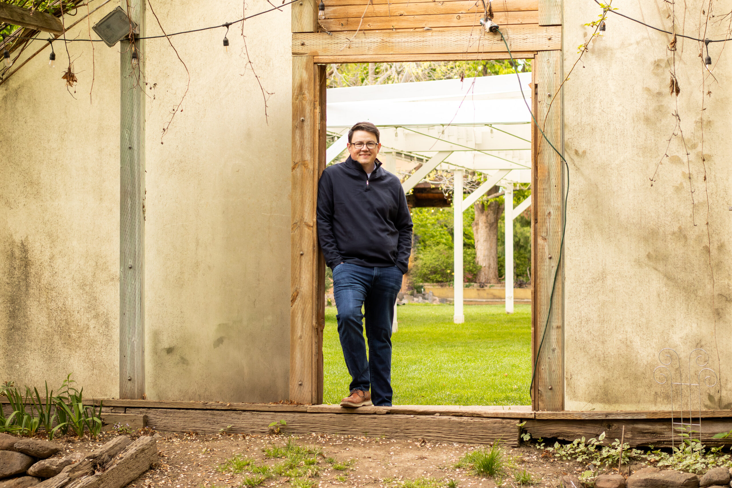 Chris Corry portrait standing in an old doorway