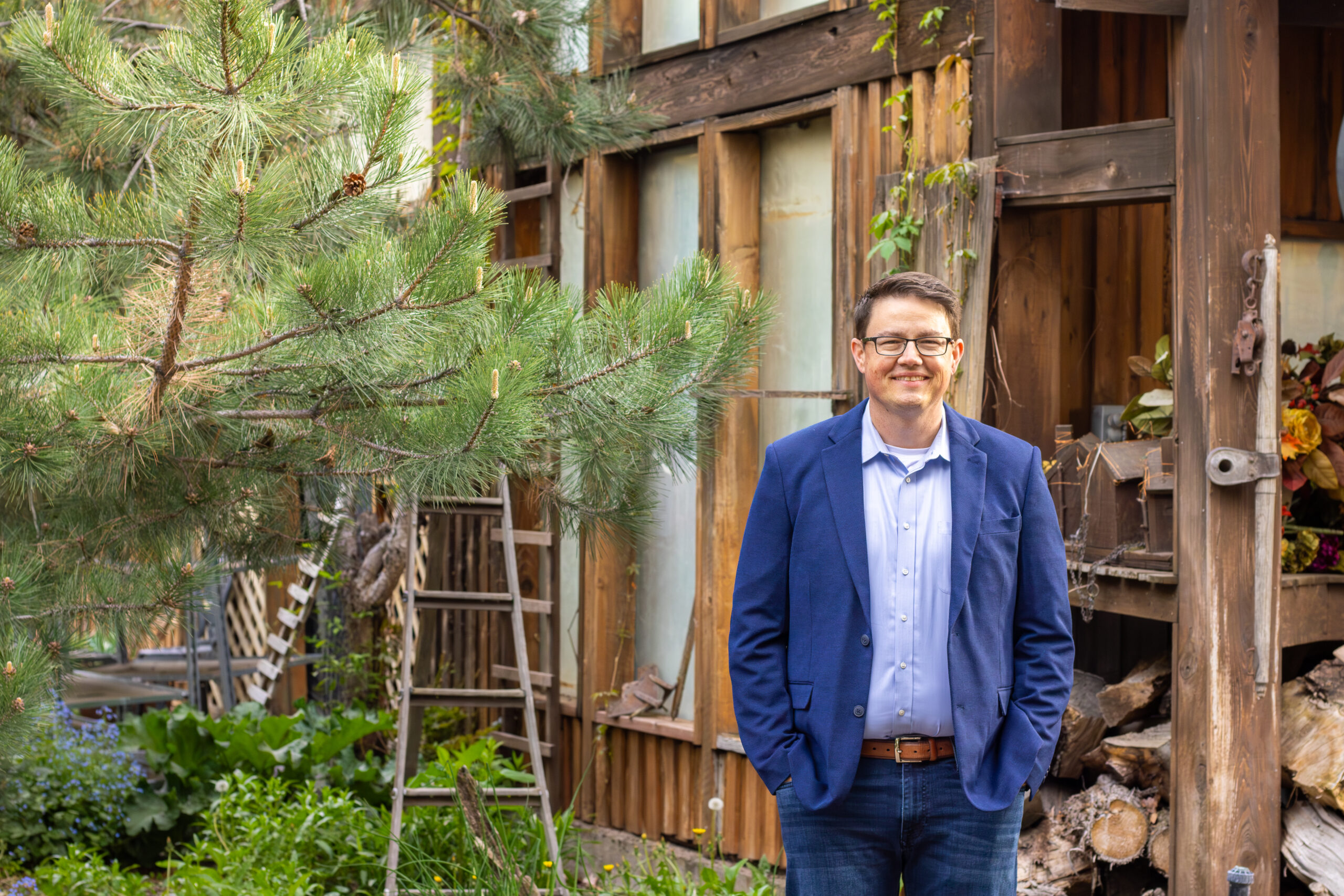 Chris Corry outdoor portrait in front of a rustic cabin