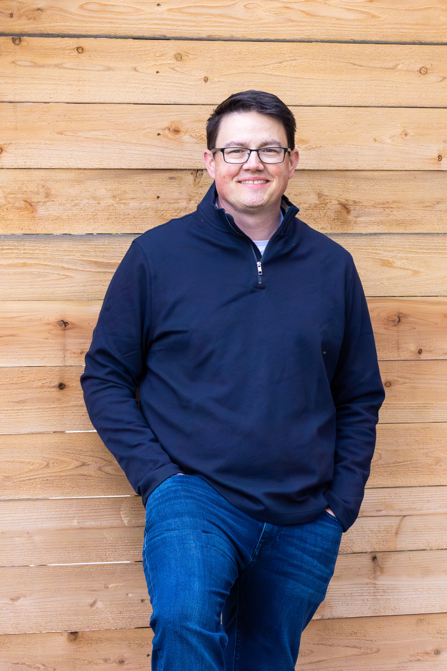 Chris Corry portrait against a wood plank wall