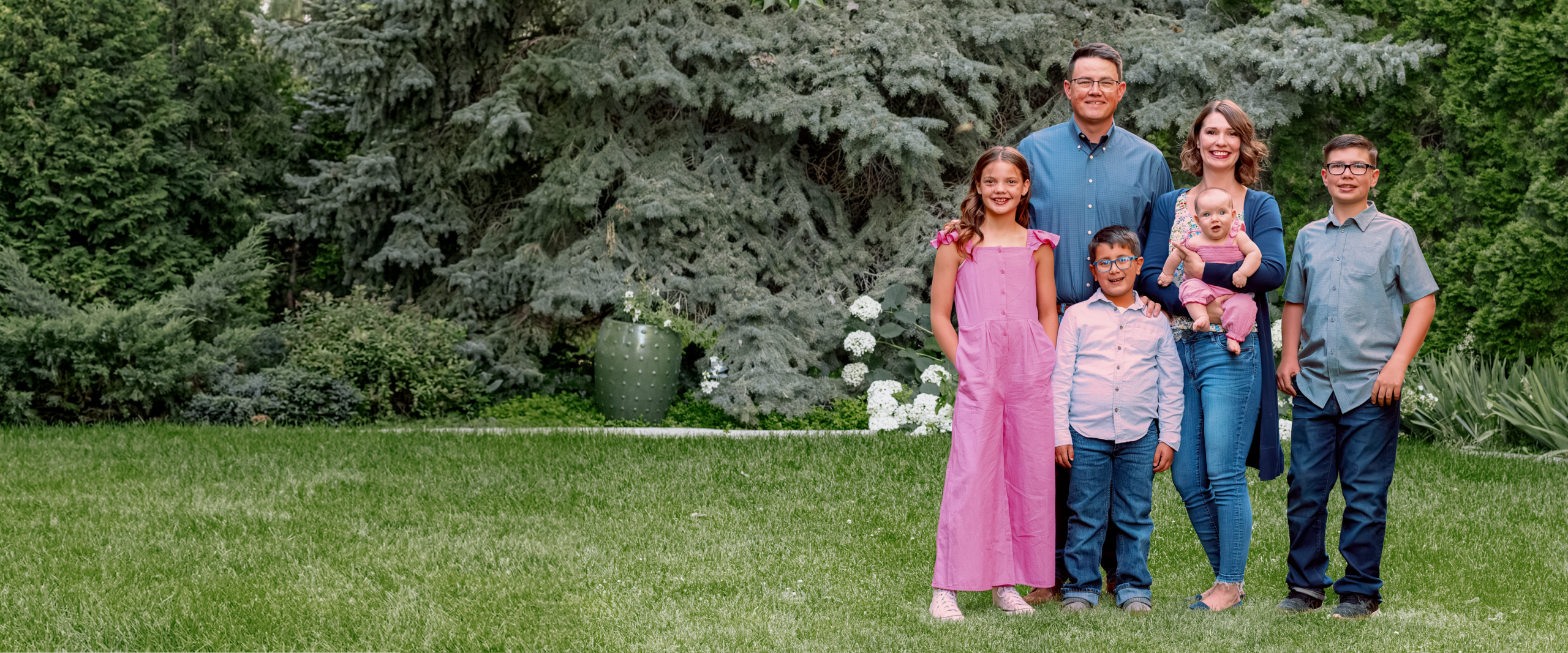 Chris Corry with his family in front of a cedar tree